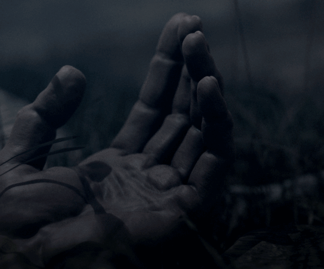 CGI close-up of a human hand resting on a dark surface with soft lighting.